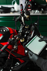 Mechanic performing system diagnostics via tablet. Motorcycle system diagnostic, scanning for...