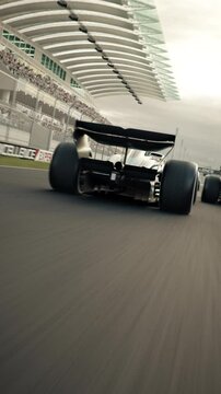 Dynamic high speed drone shot passing generic formula one race cars racing along the homestretch over the finish line. 3d animation rendering. New 2025 black and gold race car design