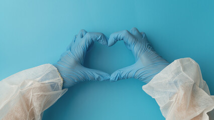 Person in latex gloves showing heart gesture against light blue background, closeup on hands.