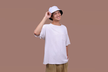 Asian Male in White T-Shirt and Hat Looking Aside on a Simple Beige Studio Setting