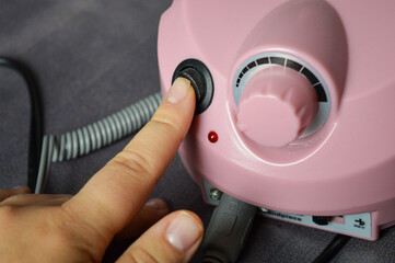 pink electric nail drill machine with attached handpiece and interchangeable bits. professional...