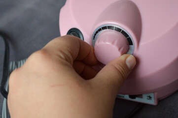pink electric nail drill machine with attached handpiece and interchangeable bits. professional...