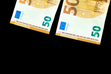 Money.Two 50 euro banknotes on black surface