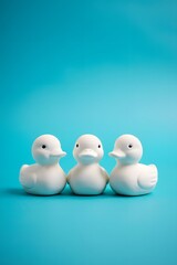 Three white rubber ducks on blue background perfect for bath time and baby shower decorations