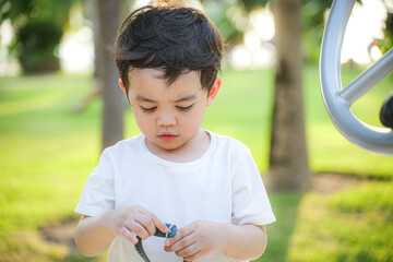 boy looking down with focus and concentration, possibly engaging in a hand activity in a calm...