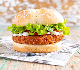 Hamburguesa de pollo con lechuga, tomate y mahonesa.