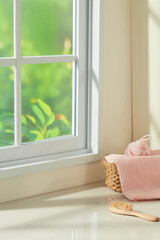Soft pastel bathroom corner with pink towel, rattan basket, and sunlight by the window. Gentle...