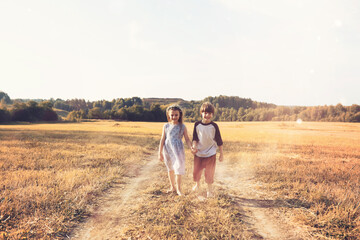 Children walk in the park in autumn. Child outdoors on a sunny summer morning in the park.