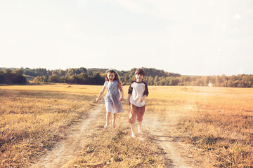 Children walk in the park in autumn. Child outdoors on a sunny summer morning in the park.
