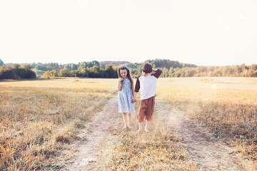 Children walk in the park in autumn. Child outdoors on a sunny summer morning in the park.
