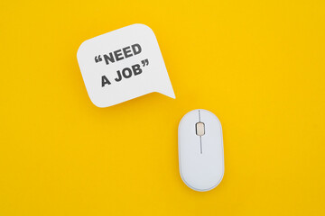 real white speech bubble paper cut with NEED A JOB in quotation marks and computer mouse on yellow background