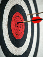 Two arrows hitting the center of target on archery target board