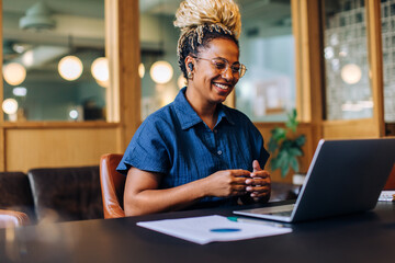 Smiling woman having a video call in a casual business setting