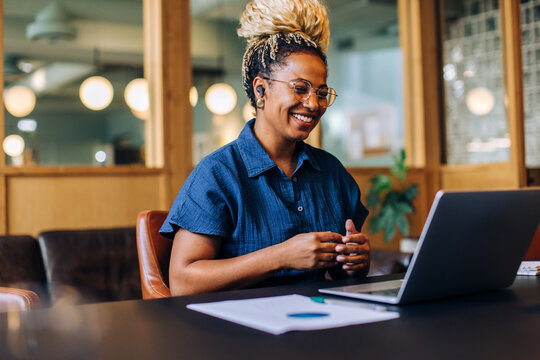 Smiling woman having a video call in a casual business setting - Powered by Adobe