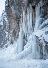 Vertical ice formations on a cliff face during winter creating a frozen cascade effect