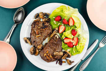 Veal steak with strawberry garnish.