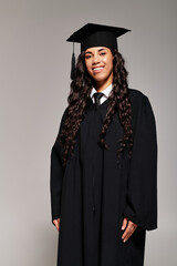 Confident young woman celebrating academic achievement in a stylish graduation gown