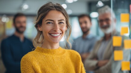 Fototapeta premium Happy confident woman smiling in office with colleagues teamwork brainstorming.