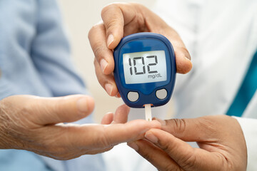 Doctor check diabetes from finger blood sugar level with finger lancet.