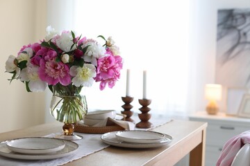 Beautiful table setting with bouquet of peonies in dining room, closeup. Space for text