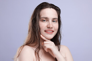 Portrait of smiling woman with natural skin complexion on grey background, closeup