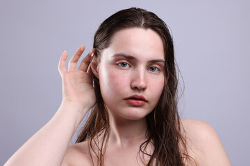 Fototapeta premium Portrait of woman with natural skin complexion on grey background, closeup