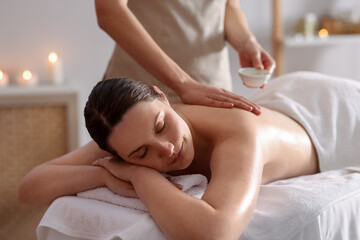 Woman receiving back massage with oil in spa salon