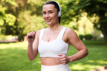 Sporty woman with headphones running in park