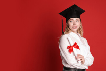Happy student with diploma after graduation on red background. Space for text