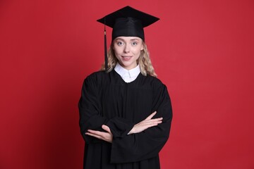 Happy student after graduation on red background