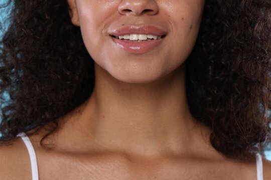 Smiling woman with glossy lip balm on her lips, closeup - Powered by Adobe