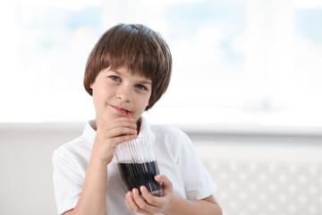 Cute little boy drinking refreshing soda at home. Space for text