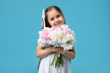 Cute little girl with bouquet of beautiful peonies on light blue background