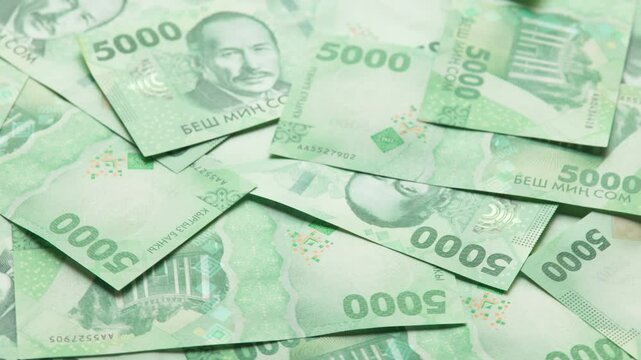 rotating background of new 5000 Kyrgyzstani Som banknotes, closeup full-frame loopable background