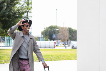 charming cheerful candid Hispanic guy go spring walk wave hand say good bye wear trendy clothes and...