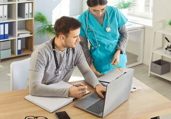 Man doctor and female nurse helping with doing paper work, discussing results of patients tests,...