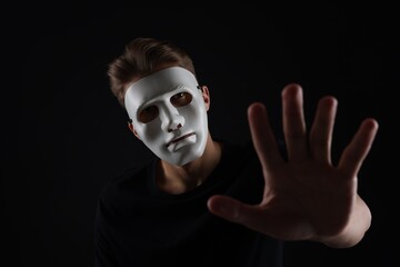 Anonymity. Man wearing mask on dark background