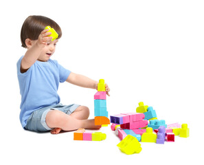 Cute little boy playing with building bricks on white background