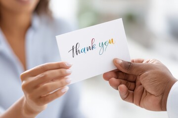 Hands exchanging a colorful thank you card to symbolize gratitude and recognition in a heartfelt moment