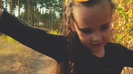 A girl in a carnival witch costume holds a bucket for candy. Trick or treat for Halloween takes candy. Childhood, traditions and fun concept. Slow motion
