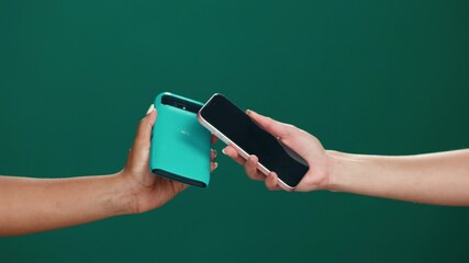 Card machine, phone and hands of people in studio for payment, transaction or contactless POS. Banking, cellphone and customer with electronic device for cashless purchase by green background. - Powered by Adobe