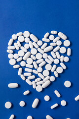 heart shaped pills on white background	