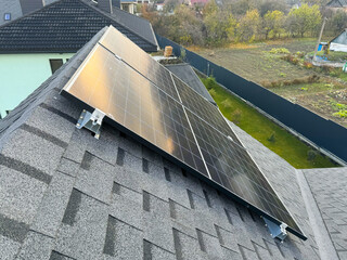 House roof with sunlight shining on photovoltaic panels
