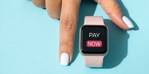 Smartwatch displaying a payment option with a finger pointing at it.