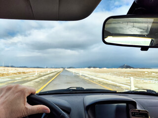 As I drive along a seemingly endless and deserted highway, the dramatic clouds overhead create an...