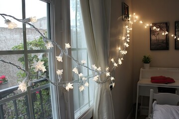 White star string lights adorn a window, illuminating a room