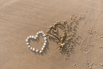 Pair Of Hearts Drawn On Sand Textured Background