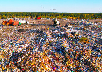 Garbage truck unloads rubbish in landfill, aerial view. Landfill waste disposal. Garbage dump with...