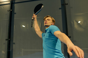 Exciting moment as young sportsman serves in competitive padel match