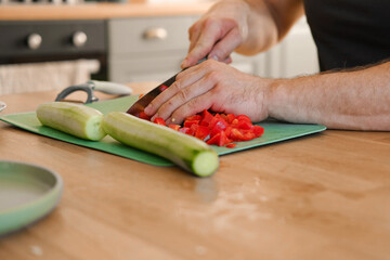 Man preparing fresh vegetables in modern kitchen, organic ingredients. Healthy meal. Cooking Food...